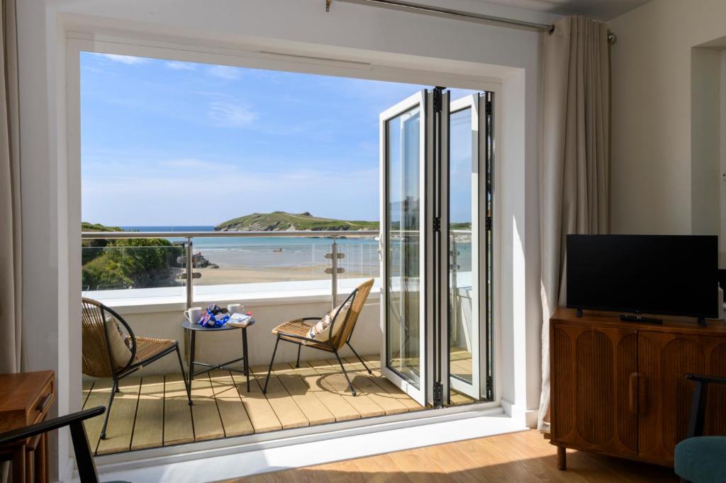 a living room with a large window with a view of the ocean at The Beach House & Porth Sands Apartments in Newquay