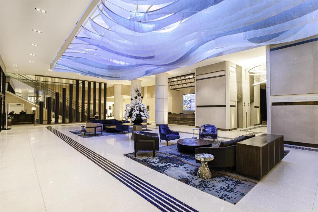 a lobby with a blue ceiling with chairs and tables at Hilton Niagara Falls/ Fallsview Hotel and Suites in Niagara Falls