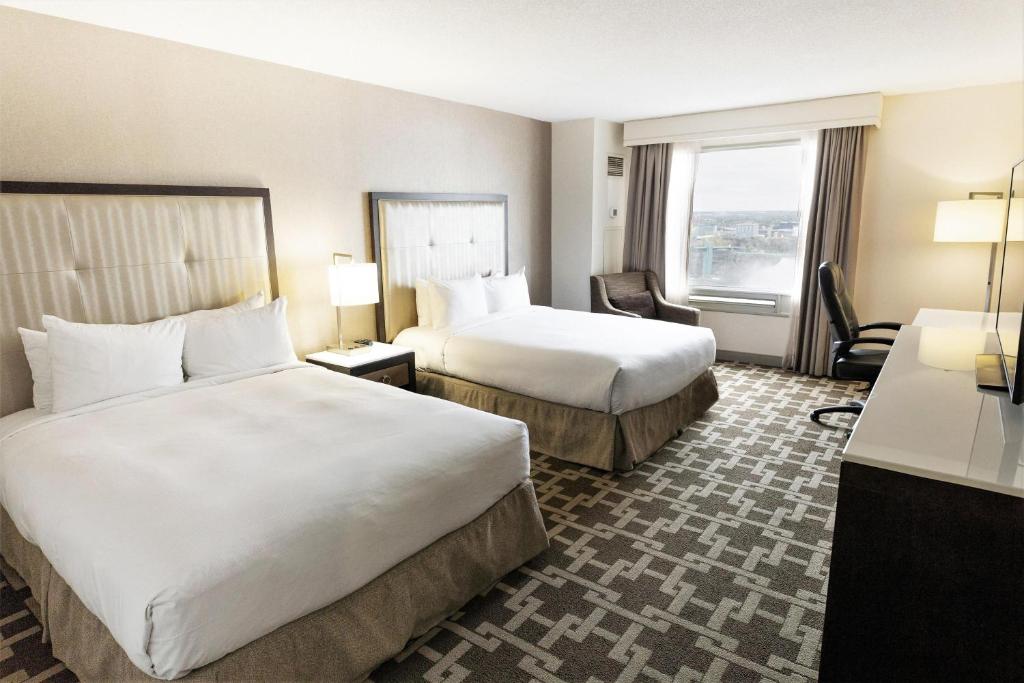a hotel room with two beds and a window at Hilton Niagara Falls/ Fallsview Hotel and Suites in Niagara Falls