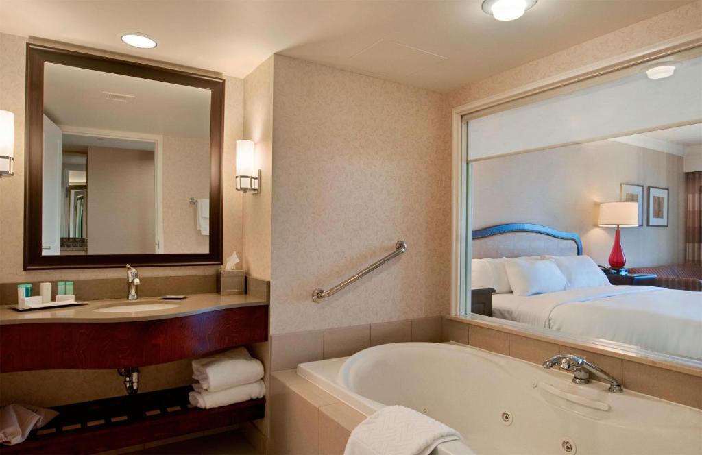 a hotel room with a tub and a bed at Hilton Niagara Falls/ Fallsview Hotel and Suites in Niagara Falls