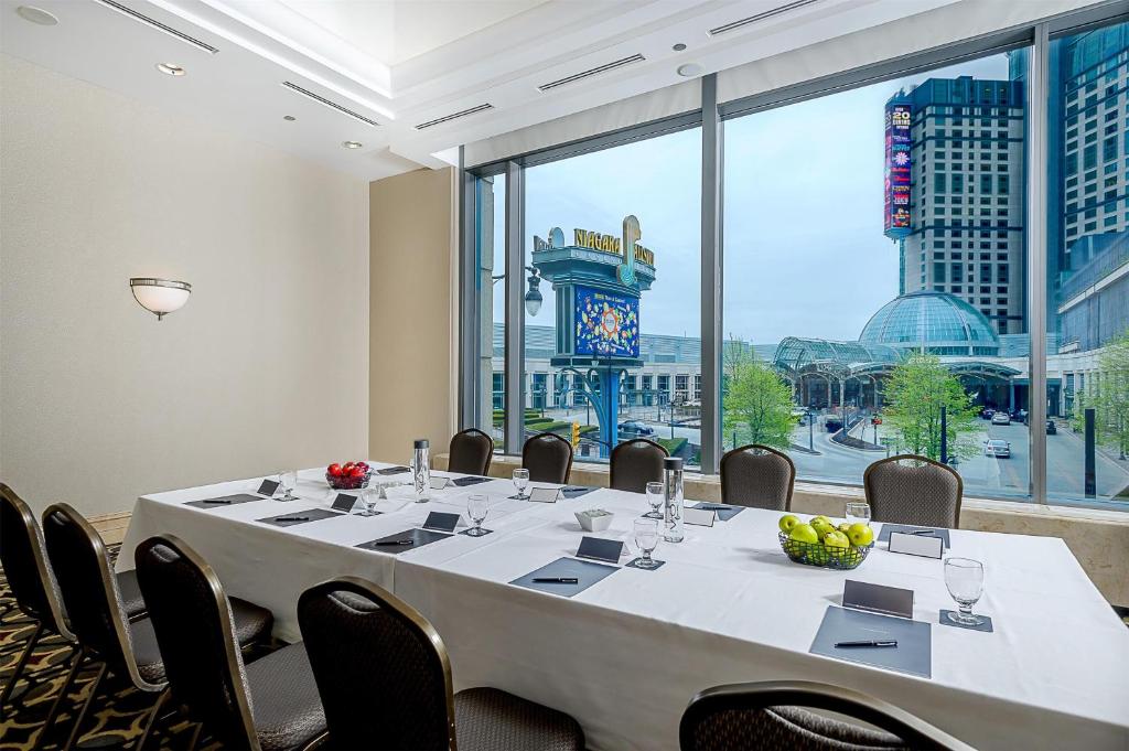a conference room with a large table with chairs and a clock at Hilton Niagara Falls/ Fallsview Hotel and Suites in Niagara Falls