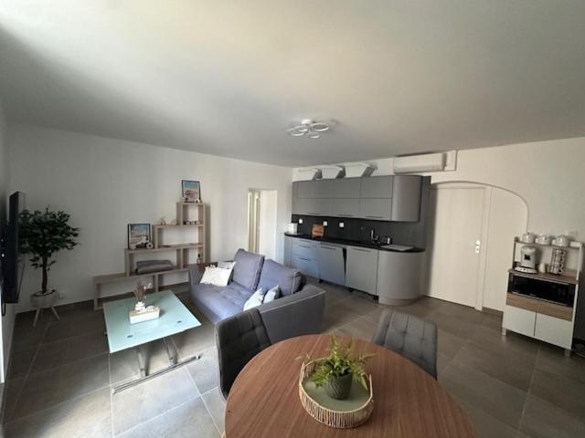 a living room with a couch and a table at Nîmes Downtown Apartment in Nîmes