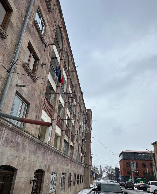 un vecchio edificio con un'auto parcheggiata accanto di Aghayan Apartment a Gyumri