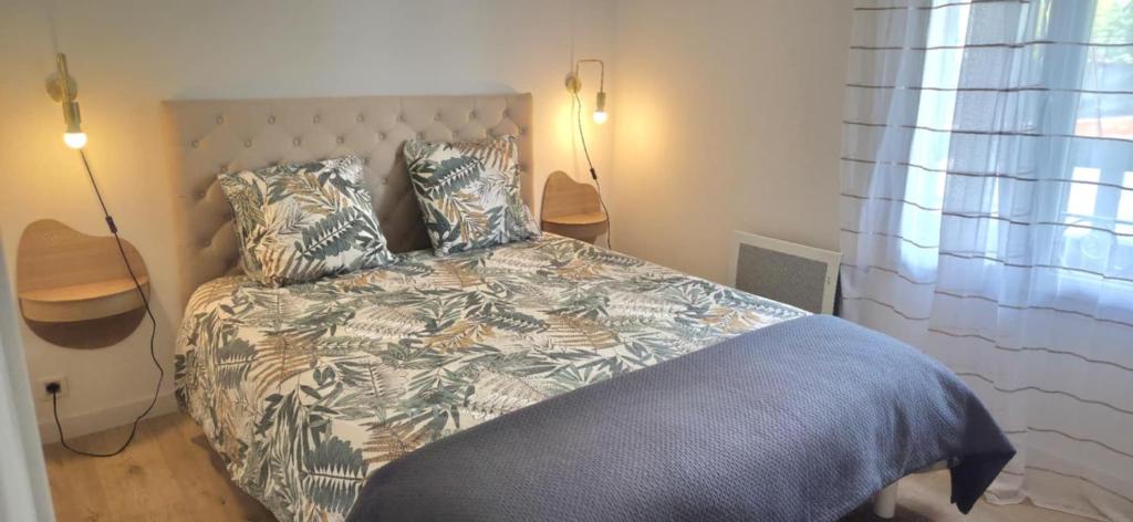 una camera da letto con un letto con una coperta e cuscini di Maison proche Clermont-Fd entre CHU et Cézeaux -Parking a Beaumont