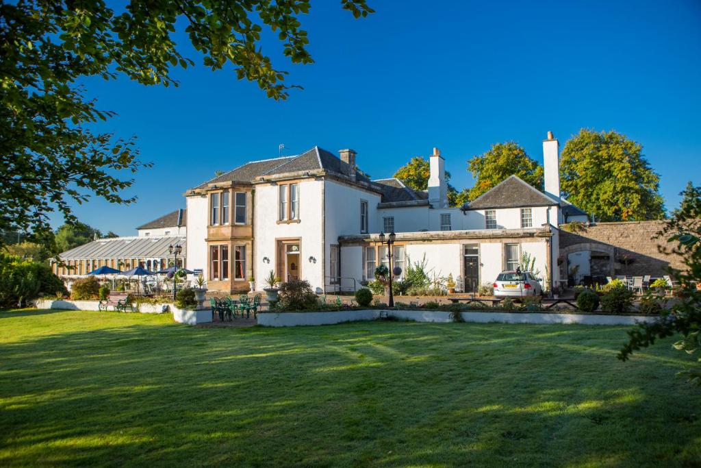 a large white house with a large yard at Maitlandfield House Hotel in Haddington