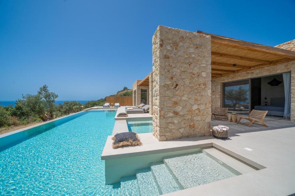 a villa with a swimming pool and a house at Lithos Art Villas - Utopia in Lakíthra