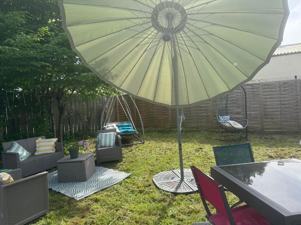 a patio with a table and an umbrella and chairs at LODGE Site escalade in Saint-Pierre-lès-Nemours