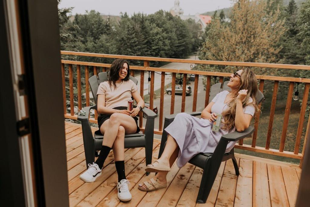 due donne sedute su sedie su un ponte di Condo Resort - Gondola 4 min walk -Terrace a Mont-Tremblant