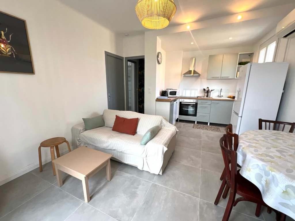 un salon avec un canapé blanc et une table dans l'établissement Valras'Loc - Le Nid Familial, à Valras-Plage