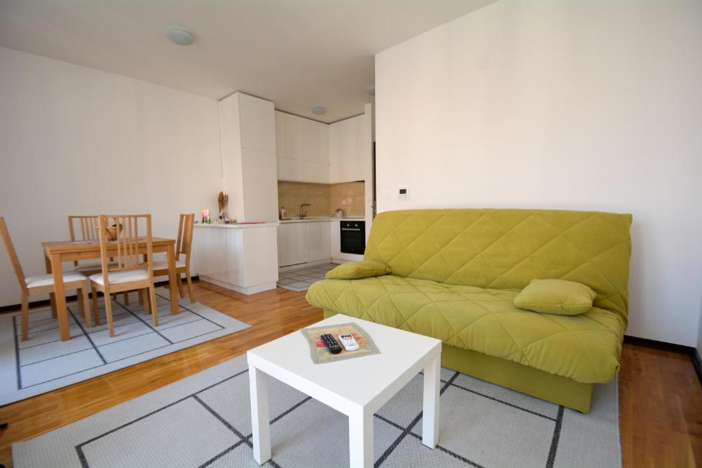 uma sala de estar com um sofá verde e uma mesa em Apartment Mirjana em Budva