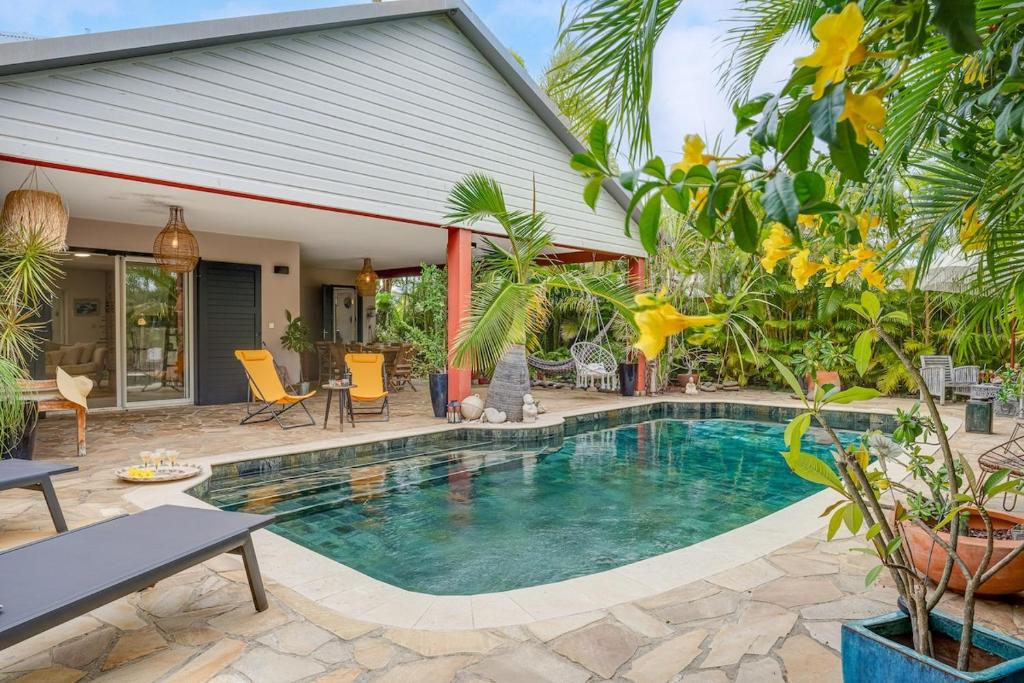 a swimming pool in front of a house at Villa Célestine in Saint-Paul