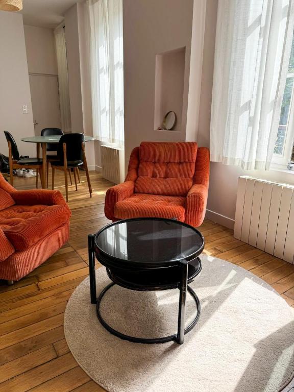 un salon avec deux chaises et une table basse dans l'établissement Cocon lumineux au coeur du 18ème, à Paris