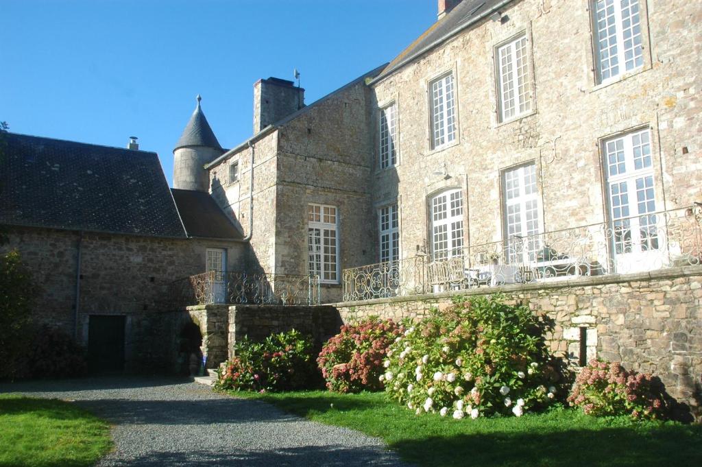 ein altes Steingebäude mit Balkon in der Unterkunft Le Chateau de Claids in Saint-Patrice-de-Claids