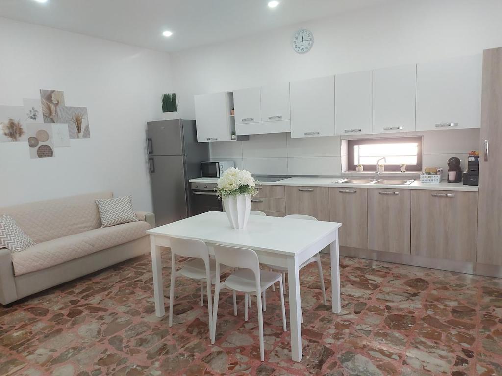 a kitchen with a white table and chairs in a kitchen at Modestina's house in Mondragone