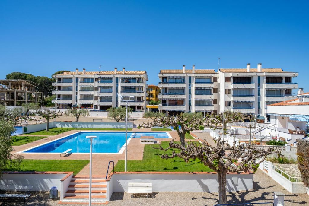 an apartment with a swimming pool and two buildings at Torrebaix in Torredembarra