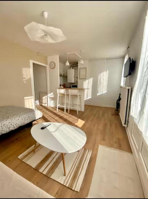 - un salon avec une table blanche et un lit dans l'établissement Appartement 151 - Proche Gare, à Montargis