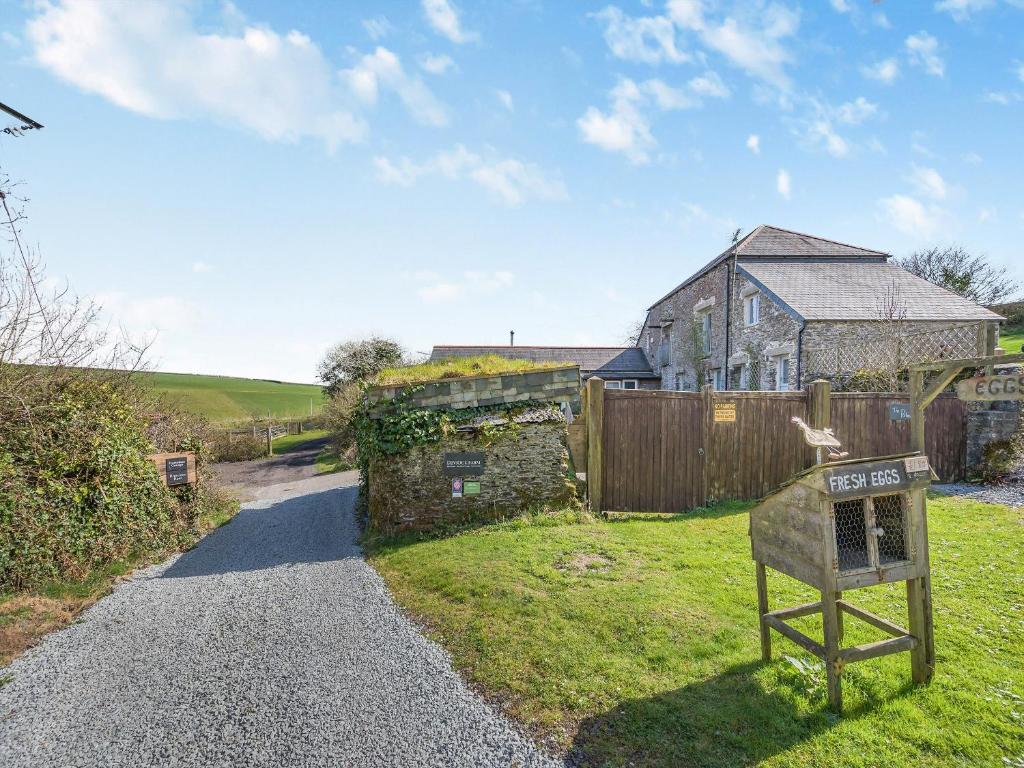 a stone house with a sign in the yard at Horseshoe Cottage - Uk48252 in Downderry