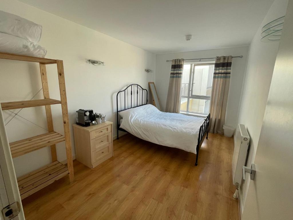 una camera da letto con un letto e un pavimento in legno di Double room with shared bathroom LGBTQ friendly a Londra