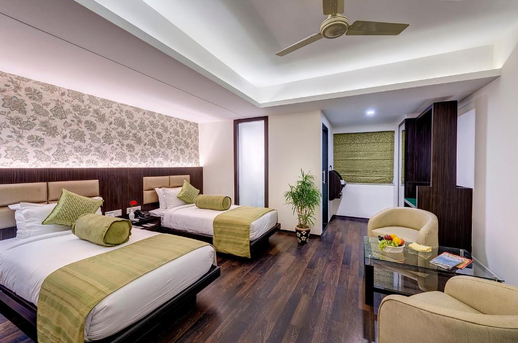 a hotel room with two beds and a table at Viceroy Boutique Hotel in Kolkata