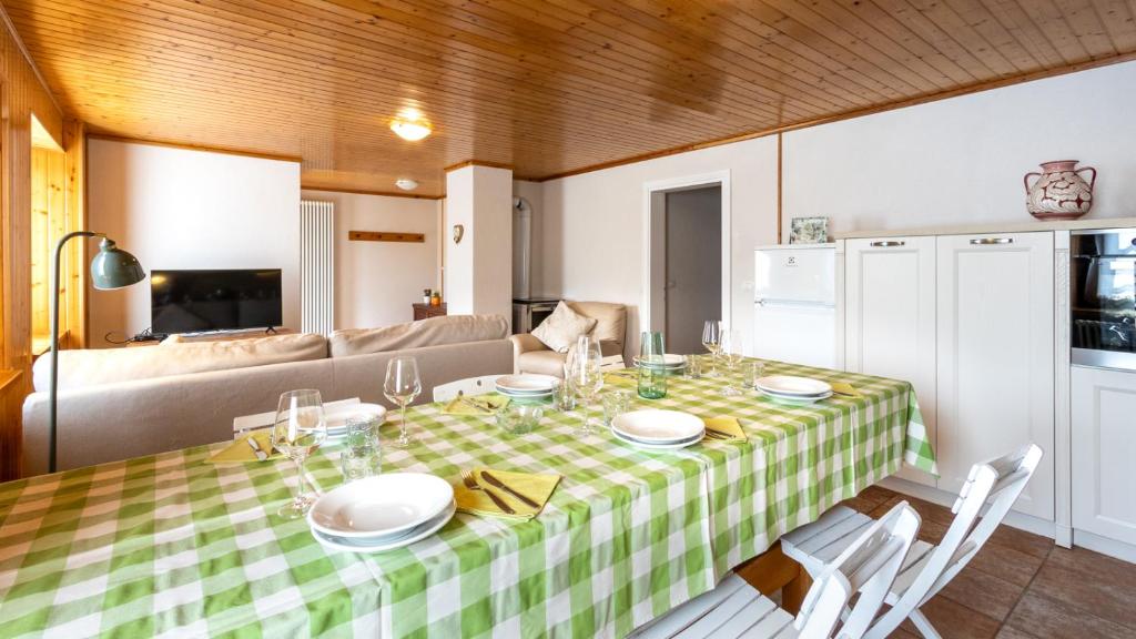 a dining room table with a green and white checkered table cloth at Casa Lateis 24 in Lateis