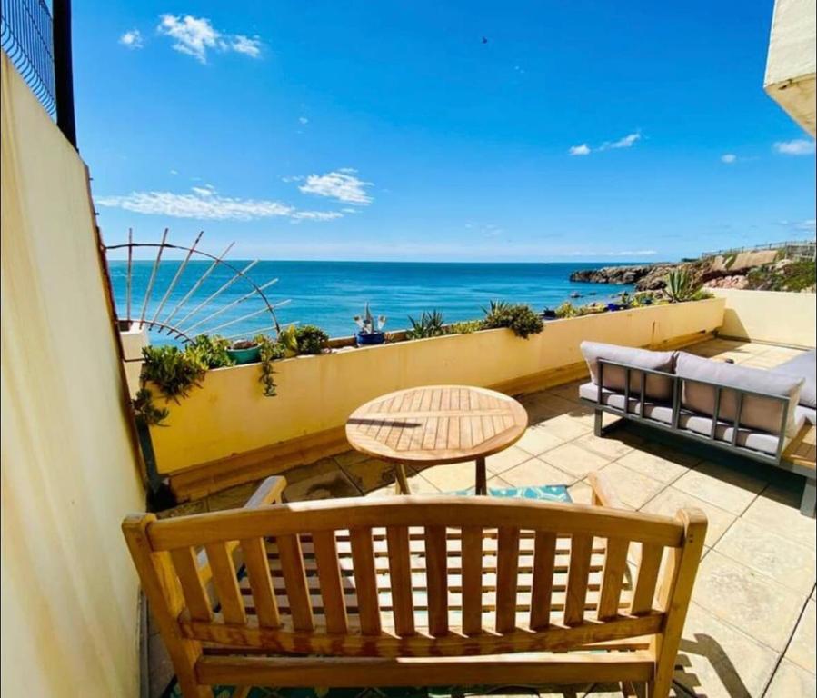 un balcon avec une table et une vue sur l'océan dans l'établissement T3 vue imprenable sur la Crique, à Sète