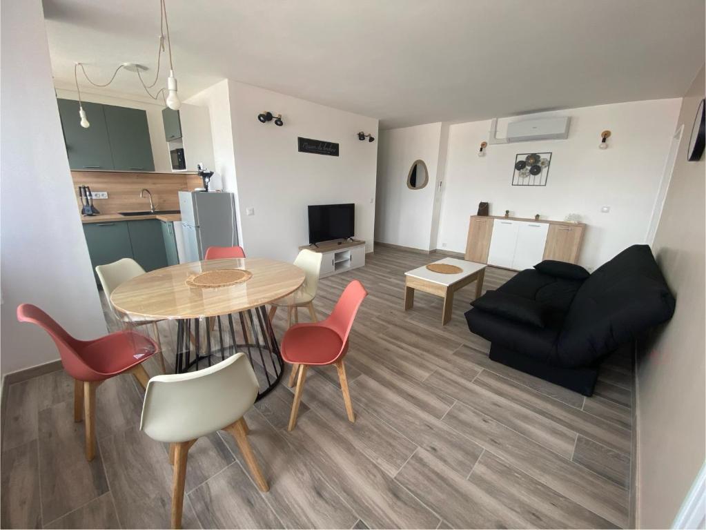 un salon avec une table, des chaises et un canapé dans l'établissement Escale nancéienne , Nancy centre , parking GRATUIT, à Nancy