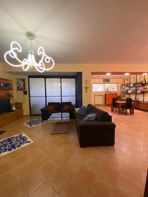 Una sala de estar con un sofá y una lámpara de araña. en B&B LA ROSA, en Salerno