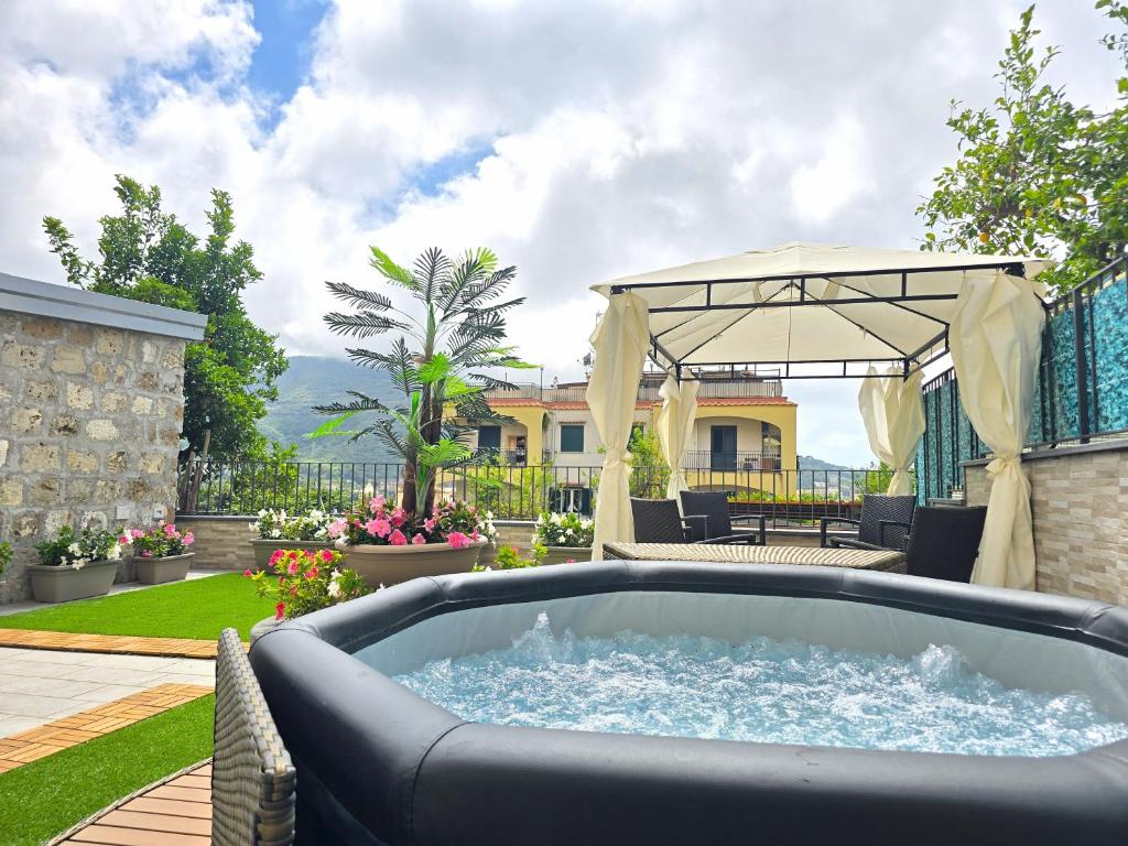 a backyard with a hot tub and a gazebo at Grazy Home - Bright new Apt with Terrace and Jacuzzi in Vico Equense