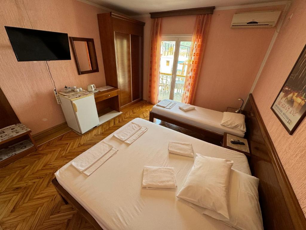 a small room with two beds and a television at ROOM 03 Villa KRIVOKAPIC in Budva