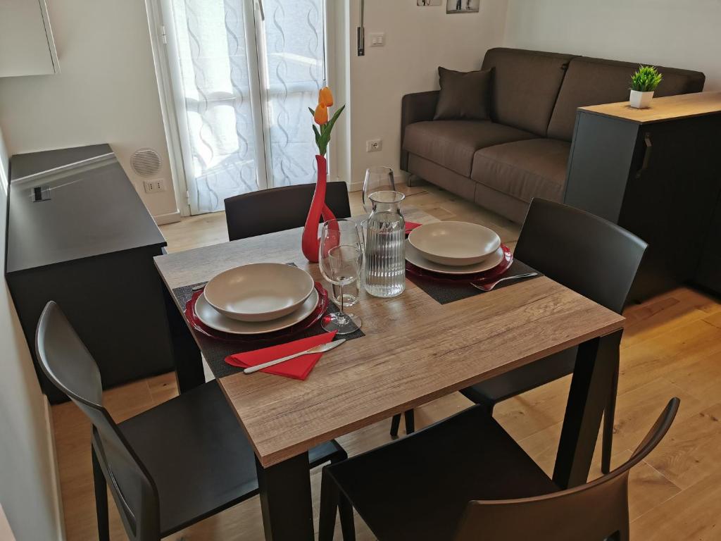 a dining room table and chairs with a wooden table and plates at Cuore Rosso in Chiavari