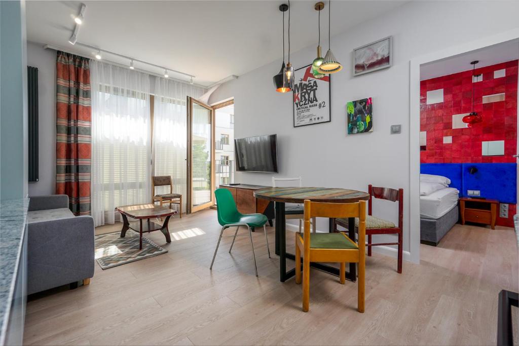 a dining room and living room with a table and chairs at Art Box - Gdańska Brzeźno in Gdańsk