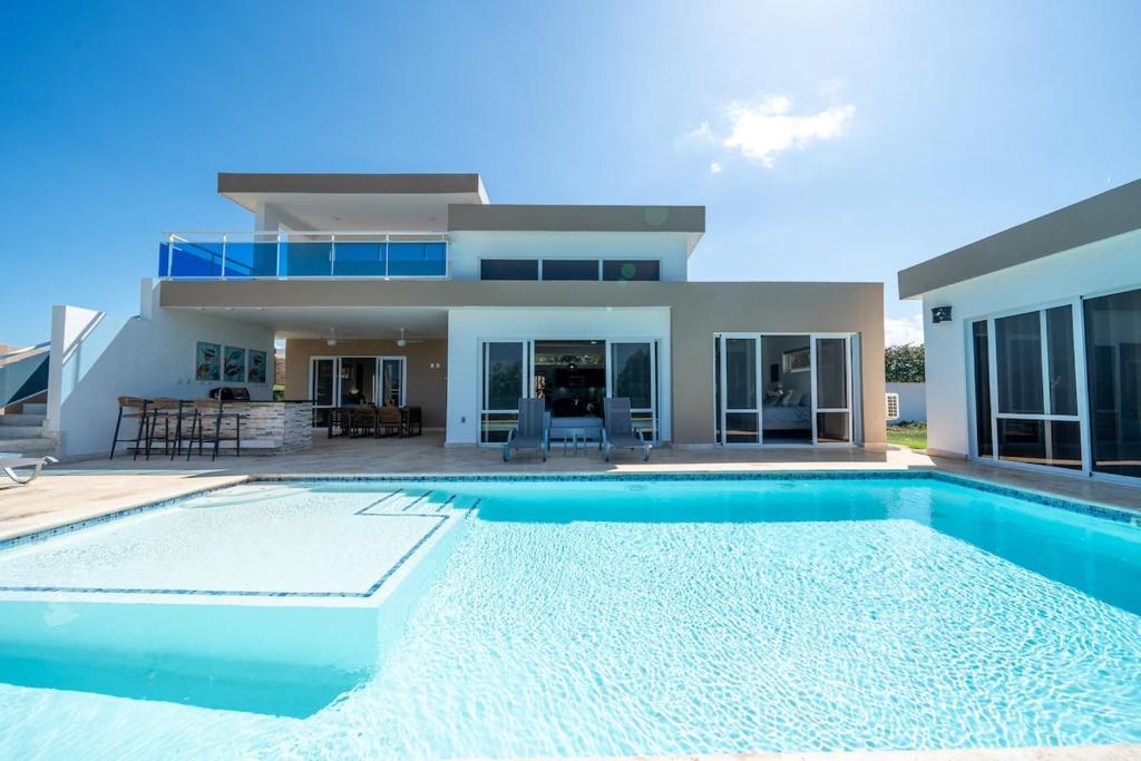 a villa with a swimming pool in front of a house at Ocean View, Style, Freedom in Sosúa