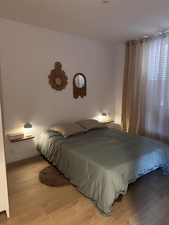 une chambre avec un lit et un miroir au mur dans l'établissement La Parenthèse - Proche de la Gare - Parking, à Valence