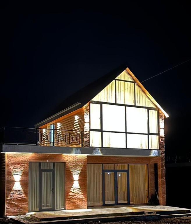 a brick house with a large window on top of it at Dream House borjomi sadgeri in Sadgeri