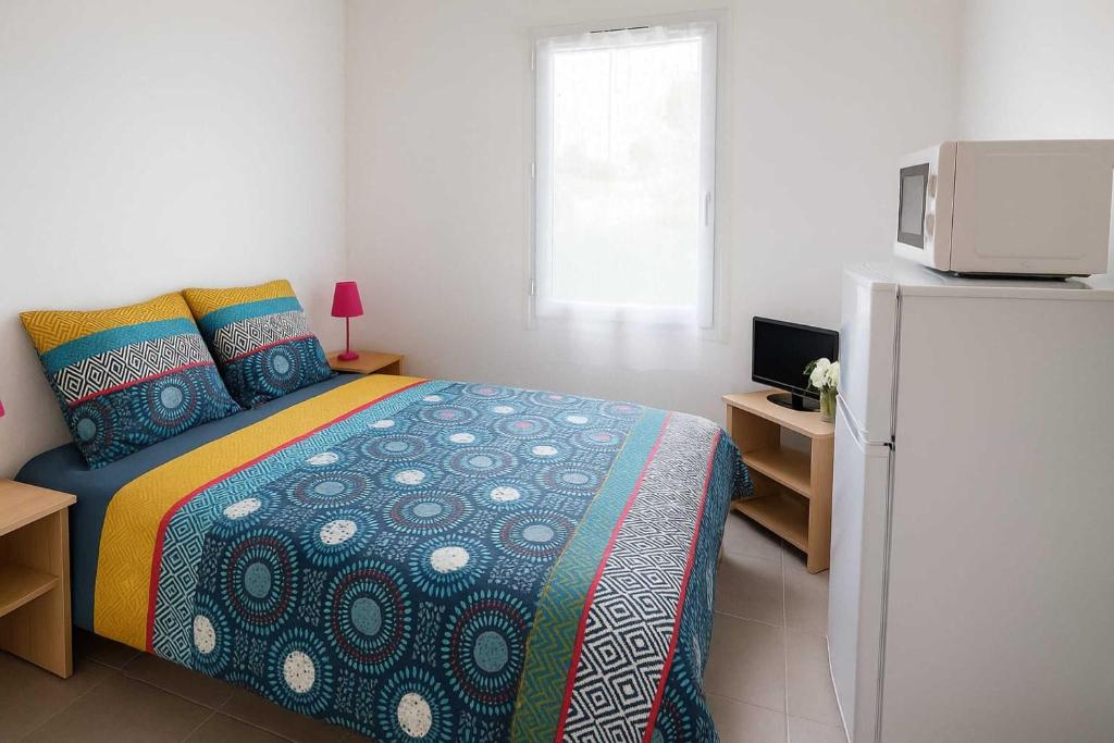 une chambre avec un lit et une télévision dans l'établissement La Coloc des Floralies - CHAMBRE CHEZ L'HABITANT - Plage des Demoiselles - Proximité Noirmoutier - Sud Nantes, à Saint-Jean-de-Monts