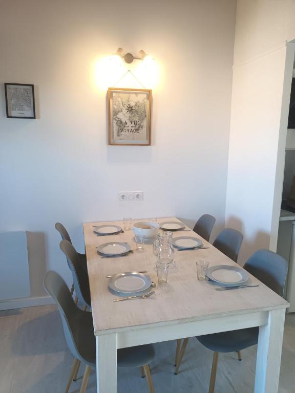 une table à manger avec des chaises et un éclairage dans l'établissement La vie est une aventure, à Talmont-Saint-Hilaire