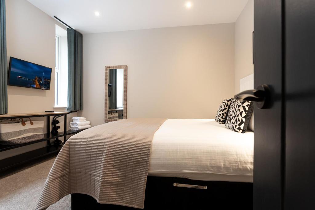 Un dormitorio con una cama y un escritorio y una ventana. en Mode Pleasure Beach Apartments, en Blackpool