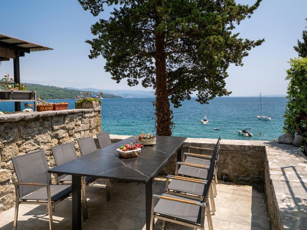 a black table and chairs with a view of the water at Casa Conrad in Opatija