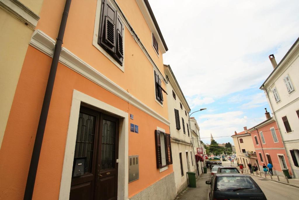 pomarańczowy budynek z drzwiami na ulicy w obiekcie Old Town Rooms and Apartment w Poreču