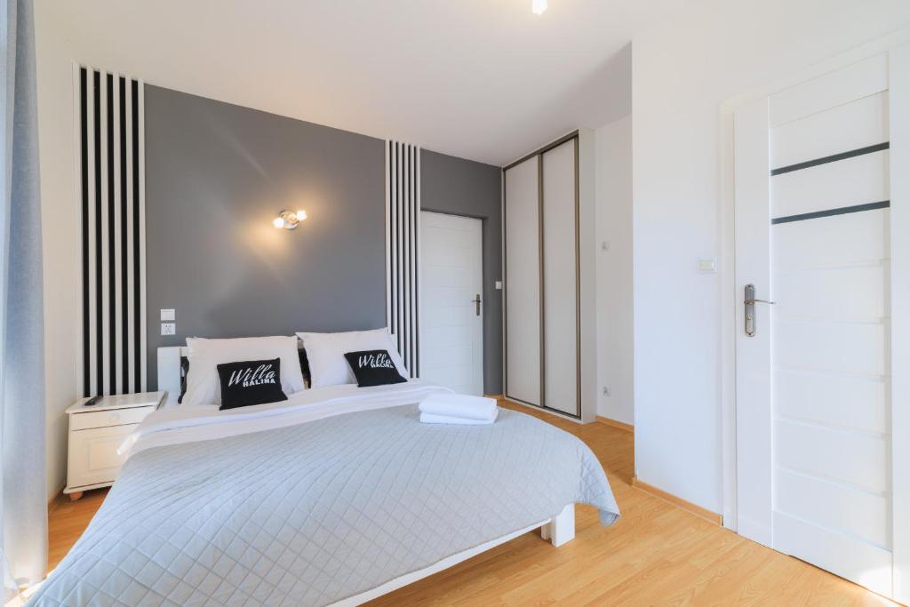 a white bedroom with a large white bed in it at Willa Halina in Krościenko