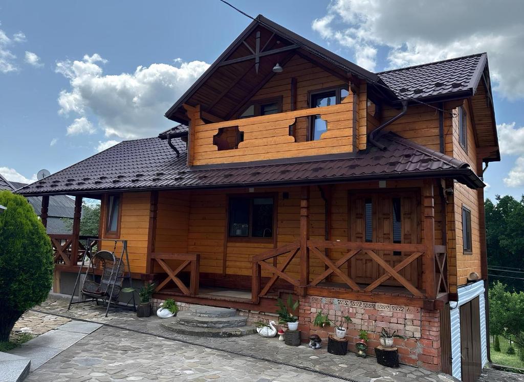 a log cabin with a gambrel roof at На Замковiй горi in Kosiv