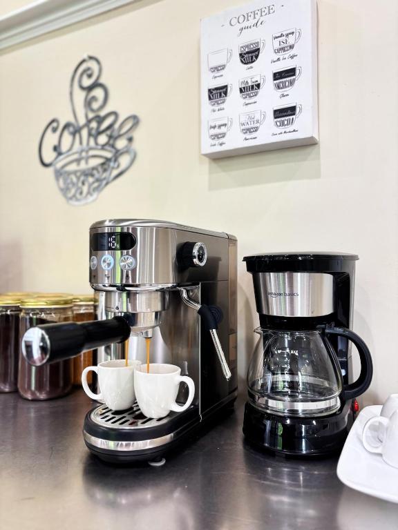 a coffee maker and two cups on a counter at Nintendo, Filtered H2O, Cafe, Central, Self-Check in Troy