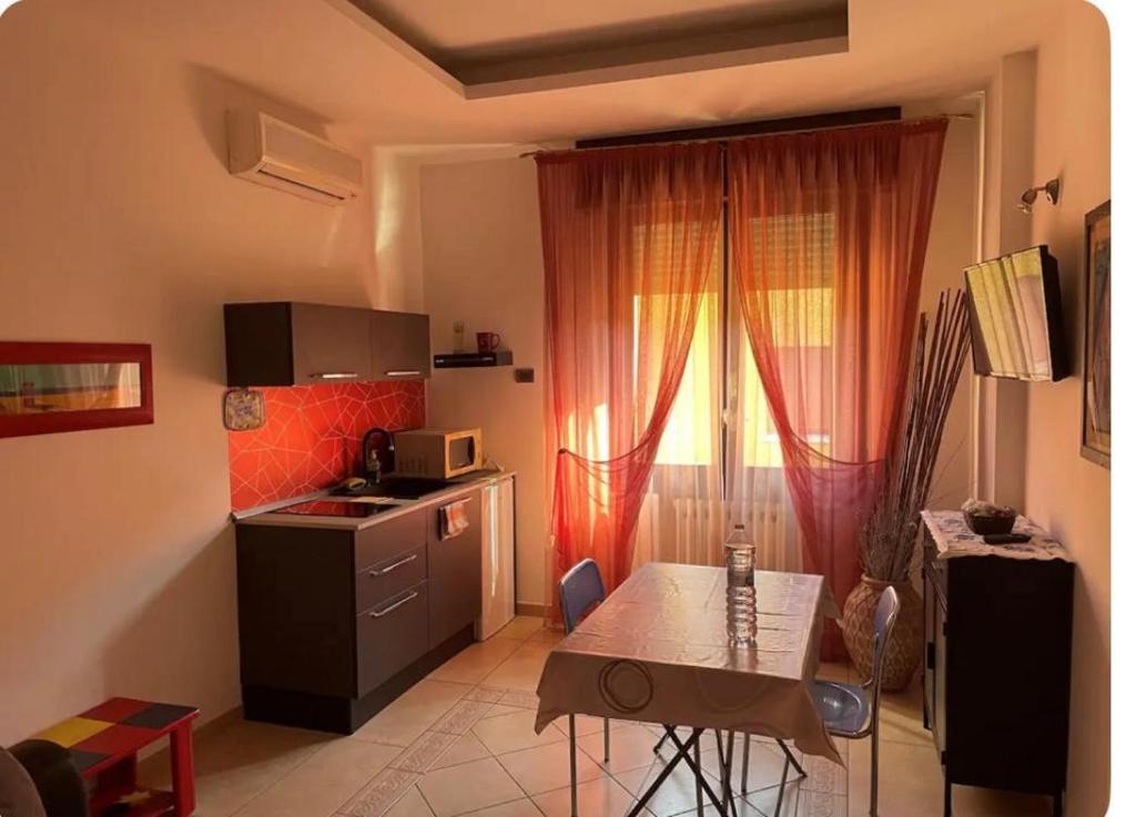 Una pequeña cocina con una mesa y un microondas. en B&B LA Sara INDIRIZZO VIA SERAFINO CALINDRI N 1, en Bolonia