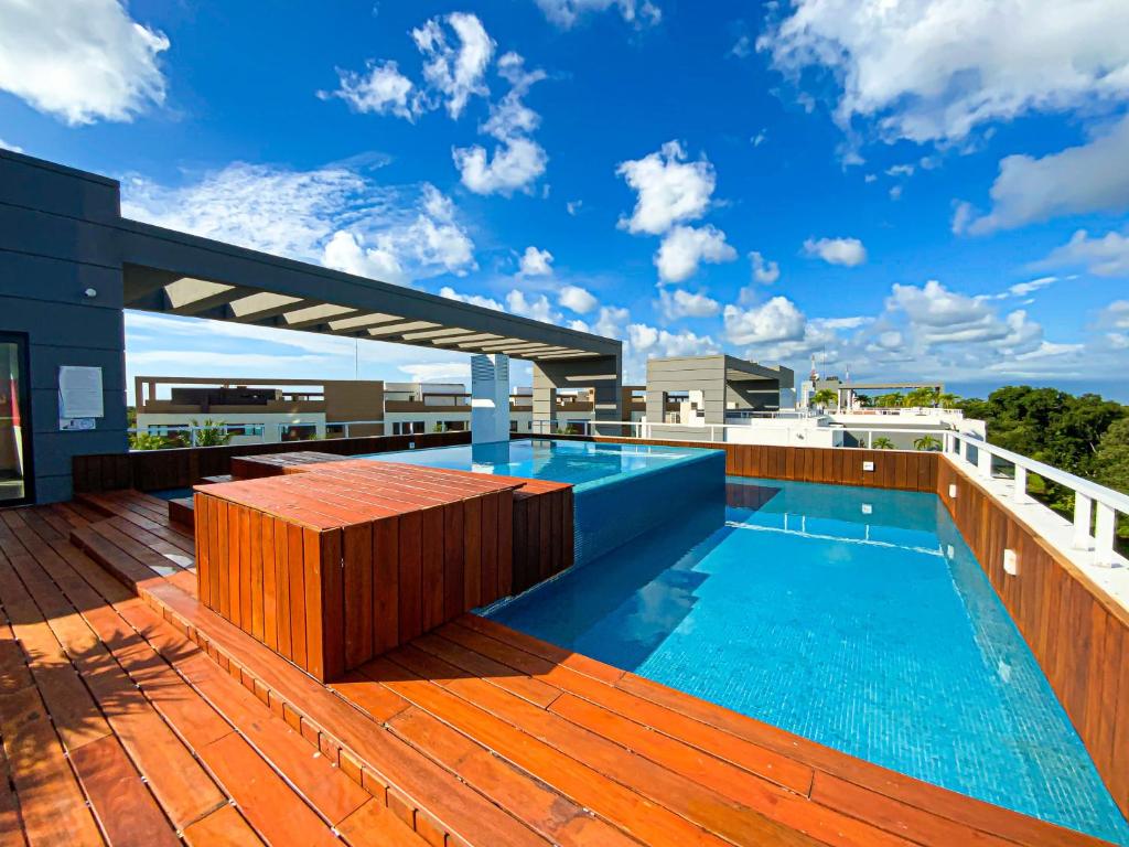 a swimming pool on the roof of a building at Corasol Condo with Rooftop Pools, Beach Club Access & Private Terrace in Playa del Carmen