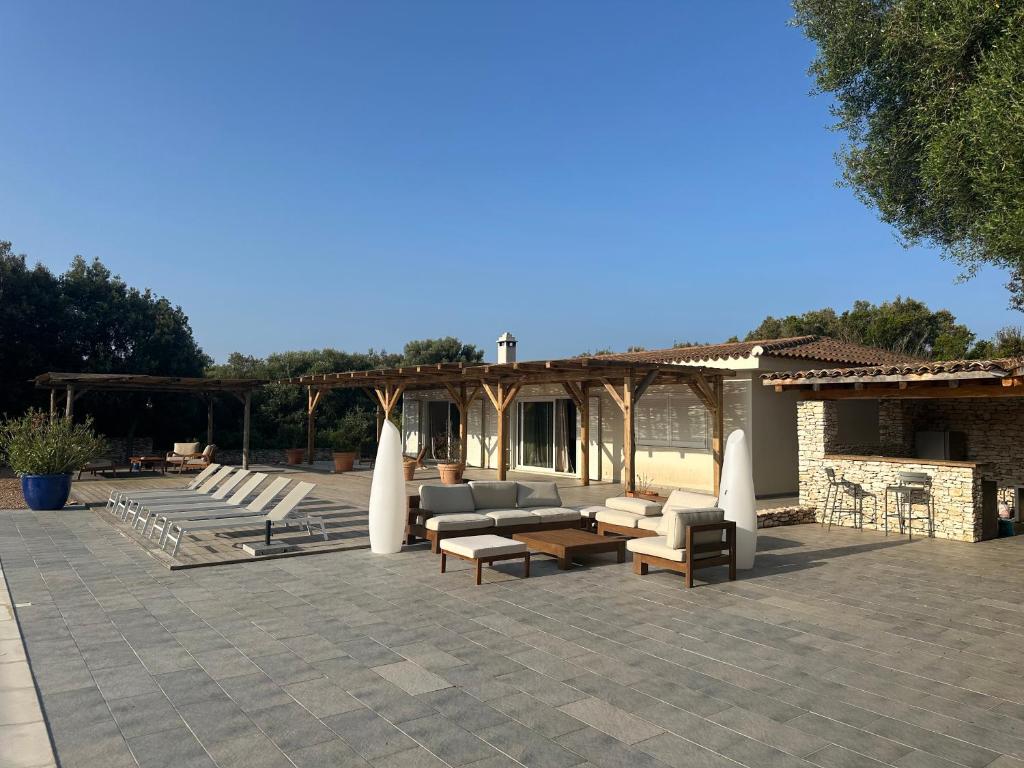 un patio avec des canapés et des chaises et un bâtiment dans l'établissement Casa Canetto, vous y êtes déjà ! 12 personnes, à Bonifacio