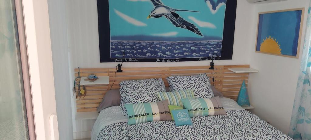 une chambre avec un lit et un tableau au mur dans l'établissement L extra Miette, à Mandelieu-la-Napoule