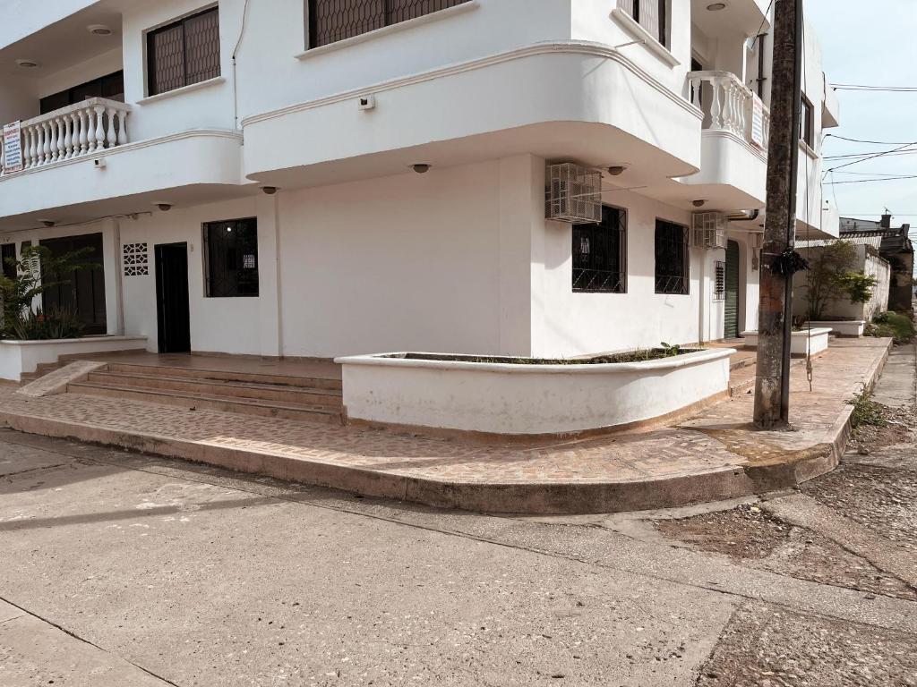 un bâtiment blanc avec un bateau sur le trottoir dans l'établissement Madili del Mar II, à Santiago