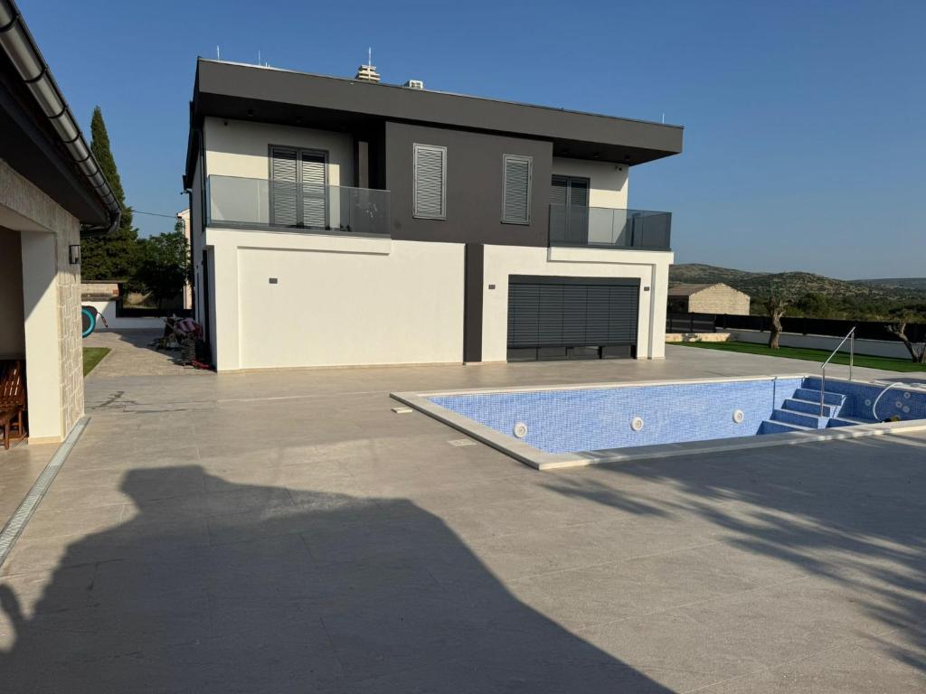 a house with a pool in front of it at Villa Karla in Konjevrate