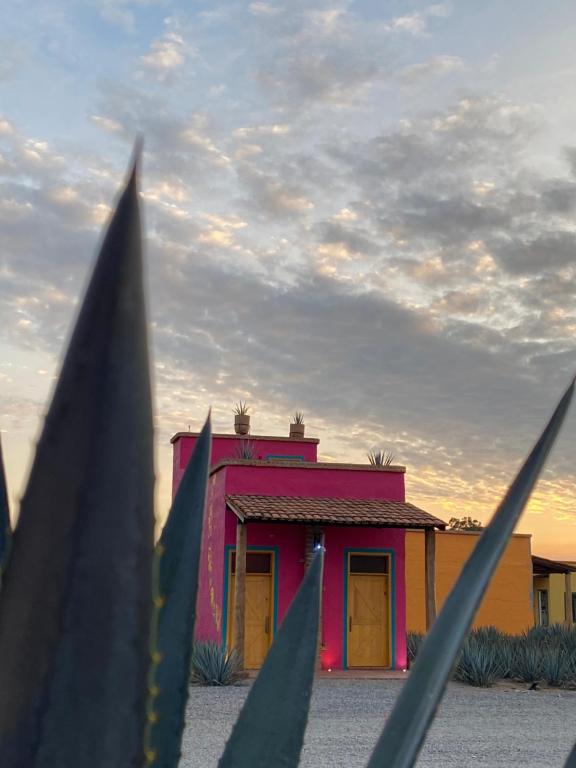a pink building with yellow doors in front at Casa Trujillo in Capilla de Guadalupe