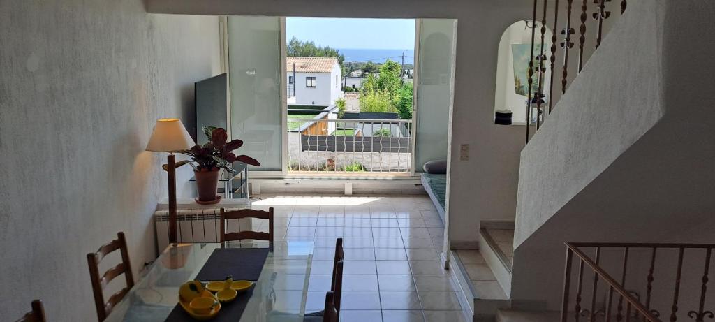 une salle à manger avec une table et une grande fenêtre dans l'établissement DUPLEX T2 vue mer avec le patio et l'arrivée autonome, à La Celle-sous-Gouzon